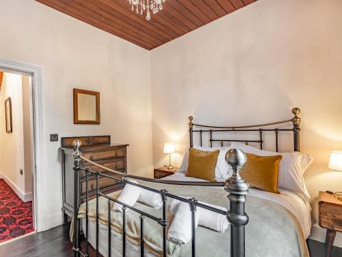 a bedroom with a bed and a chandelier at Groudd Hall in Cerrigydrudion
