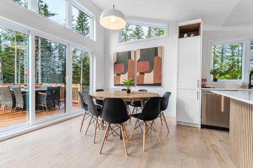 a kitchen and dining room with a table and chairs at Serene Val Amico Spa Fireplace Lake Access in Sainte-Lucie-de-Doncaster
