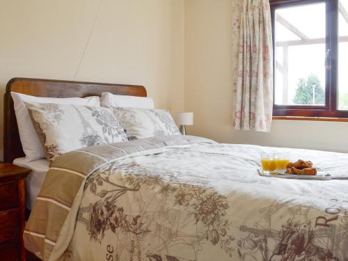 a bedroom with a bed with a tray of food on it at Three Views Bungalow in Talgarth