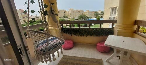 a balcony with a bench and a table and a window at Marsilia beach 3 in Dawwār Muḩammad Abū Shanab