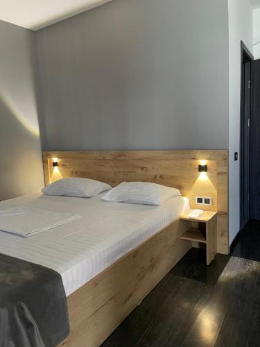 un dormitorio con una cama grande con cabecero de madera en ABC Yerevan, en Ereván