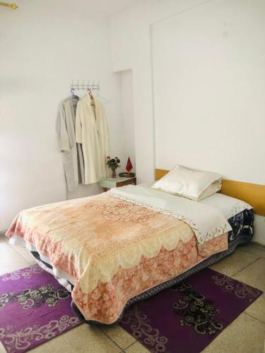 a bedroom with a bed and a rack of clothes at Cyrnos in Fez