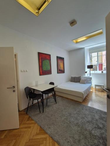 a bedroom with a bed and a table and chairs at Ritual Studio City Center in Ljubljana