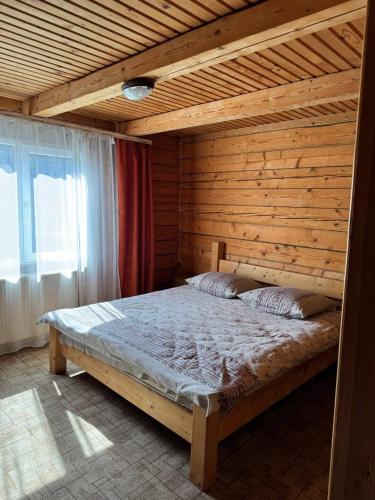 a bedroom with a bed in a wooden room at Садиба Гуцульський Двір in Vorokhta