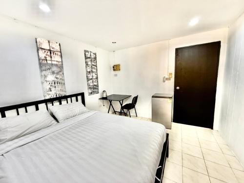 a bedroom with a white bed and a table at Patong Canal Villa R300 in Patong Beach