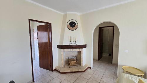 een woonkamer met een open haard met een klok aan de muur bij Casa Vista Paraíso in Carvoeiro