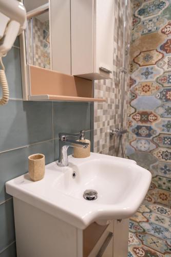 a bathroom with a white sink and a shower at Къща за гости- Къпиновата къща in Kŭpinovo