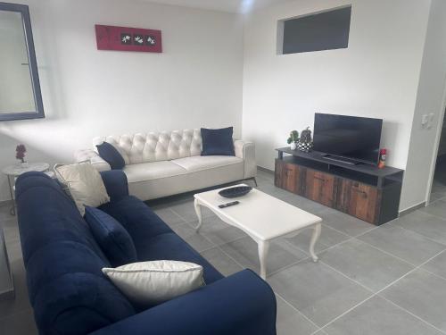 a living room with a blue couch and a tv at Auszeit am Ipf in Bopfingen