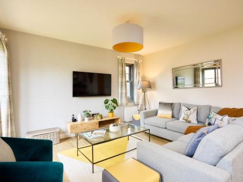 a living room with a couch and a table at Seasalt in Mundesley