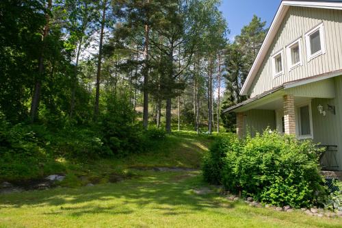 a yard next to a house with trees at Villa Talmo, Kimito island in Kemionsaari