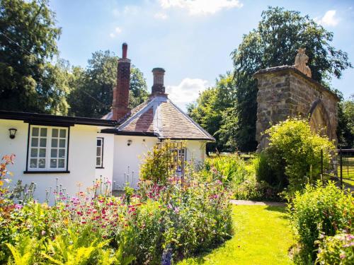 una casa antigua con flores en el jardín en Lion Gate Lodge, en Horncastle