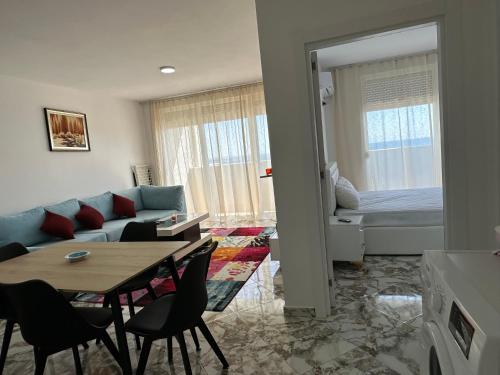 a living room with a couch and a table and chairs at Sol & Sea Apartments in Shëngjin