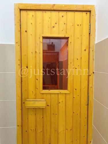 a wooden wall with a window in a bathroom at Just Stay-Inn Guesthouse The Heights Residence Melaka in Ayer Keroh