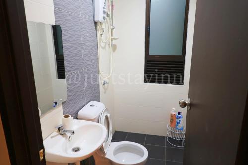 a bathroom with a white sink and a toilet at Just Stay-Inn Guesthouse The Heights Residence Melaka in Ayer Keroh
