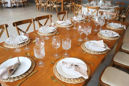 a long wooden table with plates and wine glasses at Holiday Inn Navojoa by IHG in Navojoa