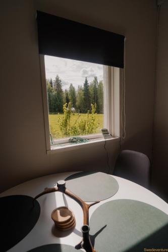 a desk with a window and a table with a lamp at Nordic Catch Cabin in Överkalix