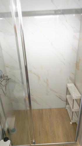 a shower in a bathroom with a marble wall at Ourania and Lena's House in Petra