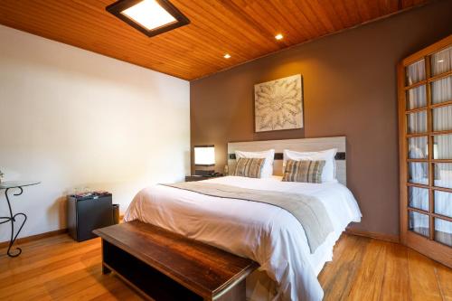 a bedroom with a large bed with a wooden ceiling at Pousada Apple House Campos do Jordao in Campos do Jordão