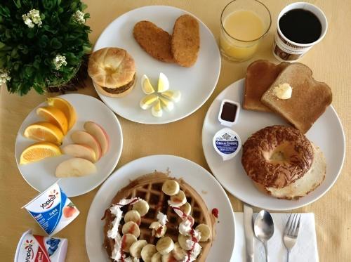 a table with plates of breakfast foods and drinks at Opus Luxury Family Serviced Apartments Gulberg Lahore in Lahore
