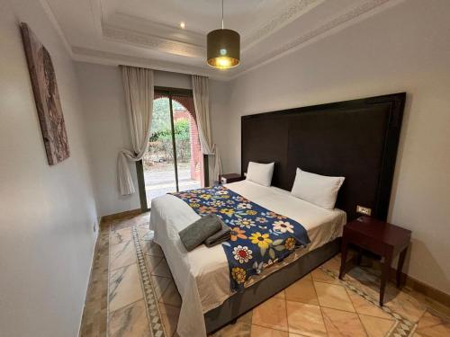 a bedroom with a large bed and a window at Appartement standing piscine la palmeraie in Marrakech