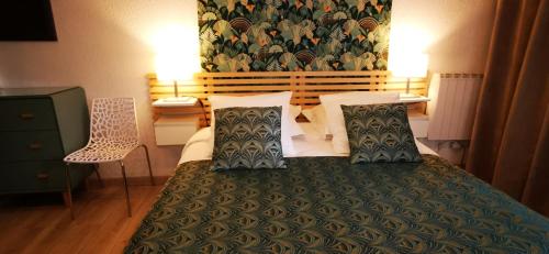 a bedroom with a large bed with a green blanket at Studio AppartHôtel OCEAN 7, Plage, Piscine, Terrasse in Biarritz