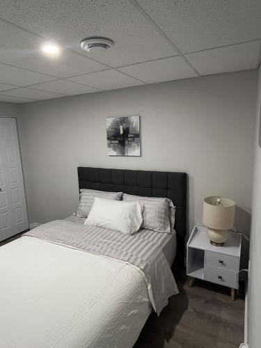 a bedroom with a bed and a lamp on a night stand at The Place in Winnipeg