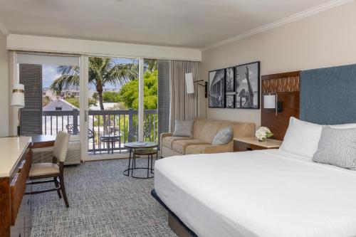 a hotel room with a bed and a desk and a room at Opal Key Resort & Marina in Key West