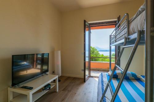 a bedroom with bunk beds and a television and a balcony at Casa Bella Vista in Laveno