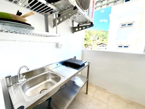 a stainless steel sink in a kitchen with a window at Patong Canal Villa R306 in Patong Beach