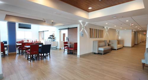 a dining room with tables and chairs and a bar at Holiday Inn Express Hotel & Suites Cincinnati Southeast Newport by IHG in Bellevue