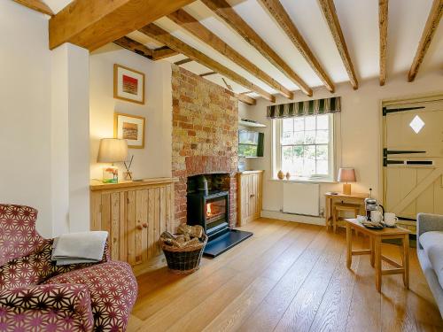 a living room with a couch and a fireplace at Rose Cottage in Poynings
