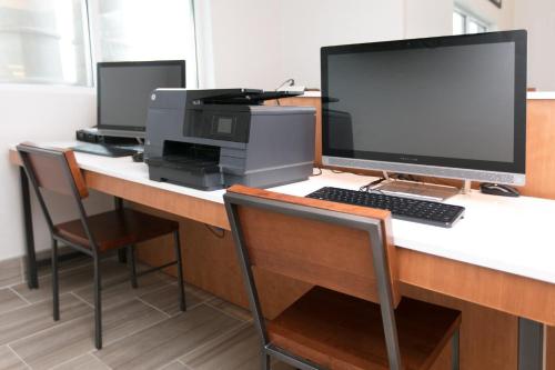 an office with a desk with a computer and a printer at Holiday Inn Express Hotel & Suites Cincinnati Southeast Newport by IHG in Bellevue