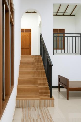 a hallway with wooden stairs and a door at galle villa in Galle