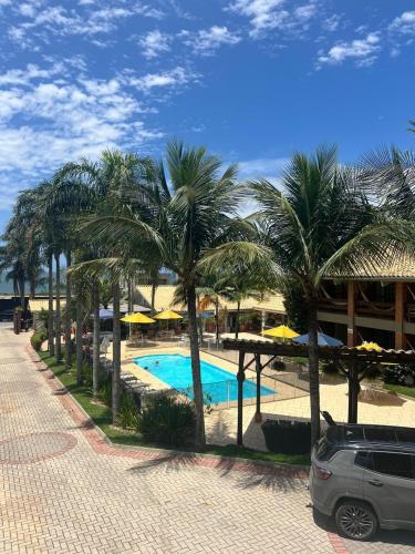 a resort with a swimming pool and palm trees at Pousada Ponta do Lobo in Balneário Camboriú
