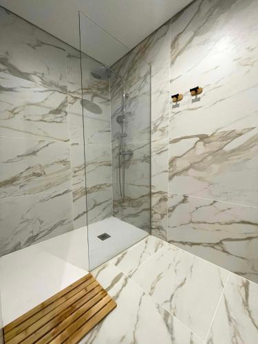 a bathroom with a shower with a bench in it at Torreira Beachside House in Torreira