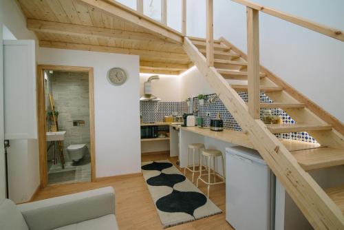 uma cozinha e sala de estar com escadas num loft em Loft 11 em Olhão