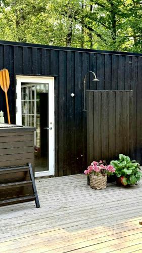 a patio with a black fence and a basket of flowers at Wooden House With Animals And Kayaks Near Aalborg in Aalborg