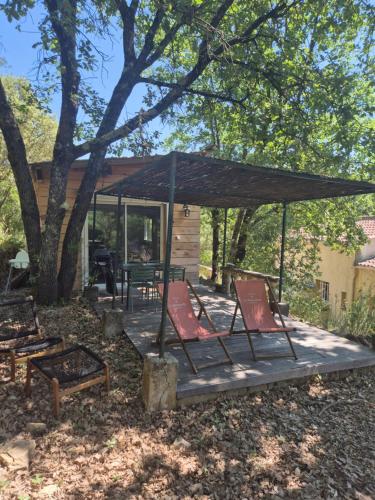a deck with chairs and a table and a pavilion at Maisonnette au cœur de la nature in Néoules