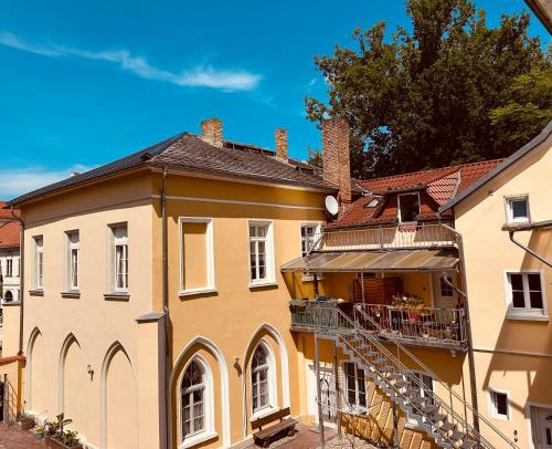 a large yellow building with a staircase in front of it at Schlosswache21 in Zerbst