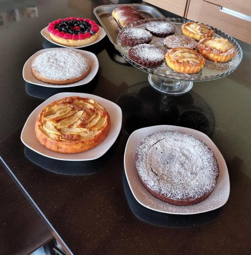 a table topped with plates of pastries and donuts at GIO' HOUSE in Fossano