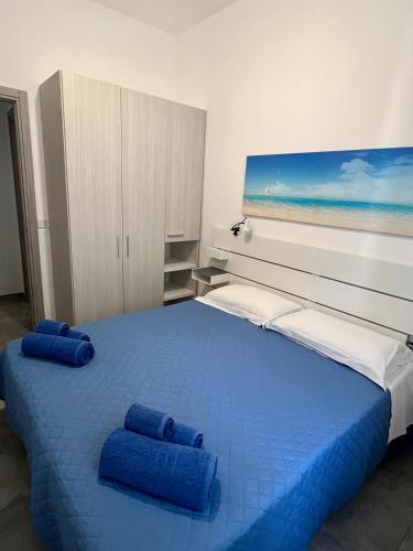 a bedroom with a large bed with blue pillows on it at Casa FOXI MANNA in Tertenìa