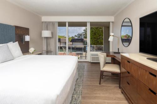 a hotel room with a bed and a desk and a television at Opal Key Resort & Marina in Key West