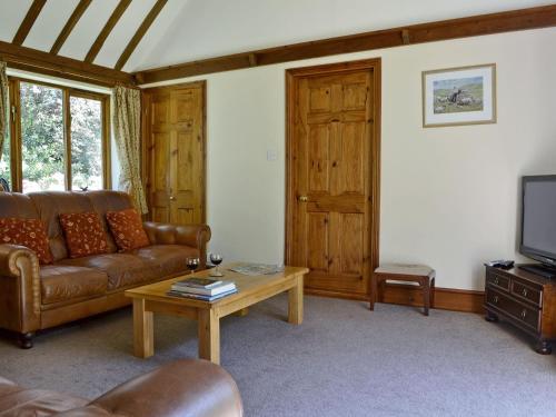a living room with a couch and a coffee table at Ivy Cottage in Sandhurst