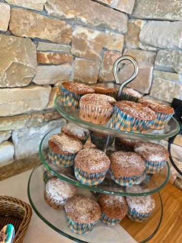 a three tiered display with cupcakes and muffins on it at Świerkowe Chatki w Koniakowie in Koniaków
