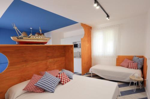a room with two beds and a boat on the ceiling at A' Terrazza in Santa Flavia