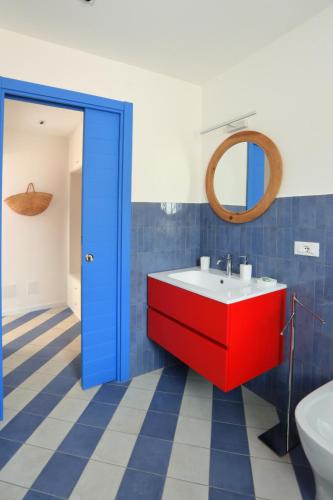 a bathroom with a red sink and a mirror at A' Terrazza in Santa Flavia
