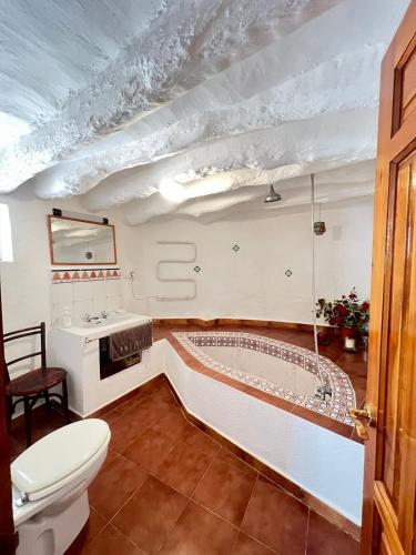 a bathroom with a tub and a toilet and a sink at Casa Estrella de la Alpujarra in Almegíjar