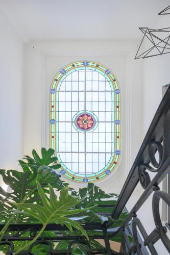 a stained glass window in a room with a plant at FAUNA Montevideo in Montevideo