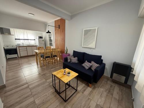 a living room with a blue couch and a table at Casa Vélez - cómoda, moderna y bien ubicada en Tres Arroyos in Tres Arroyos