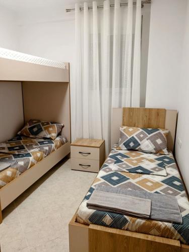 two beds sitting next to each other in a bedroom at Old Beach Apartments 2 in Vlorë